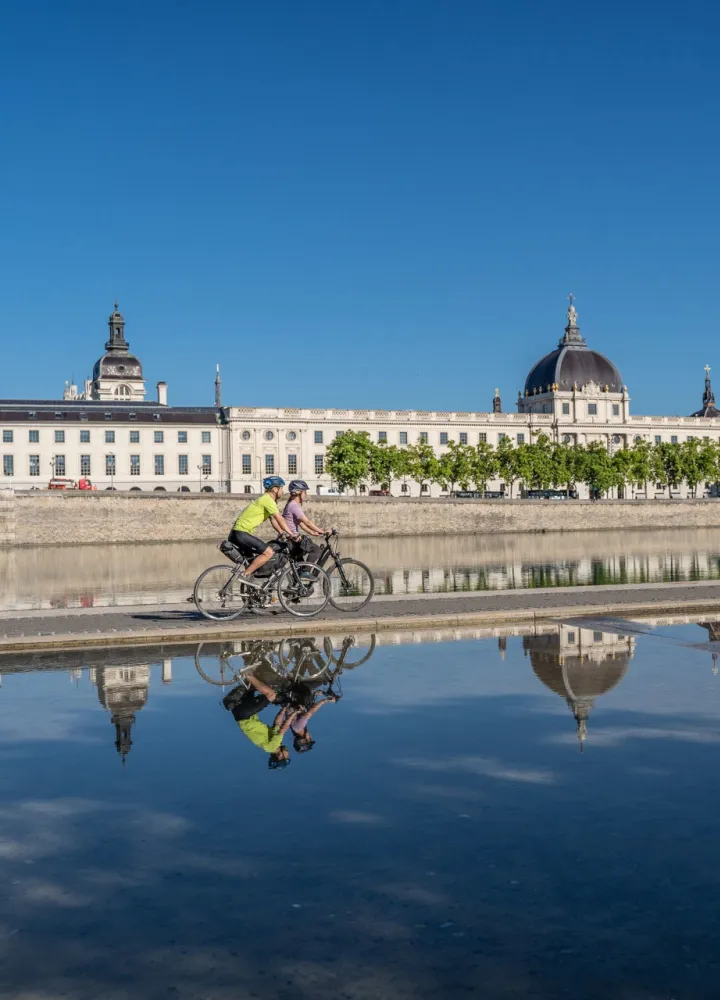Cyclists passing in front of the Grand Hôtel-Dieu in Lyon
