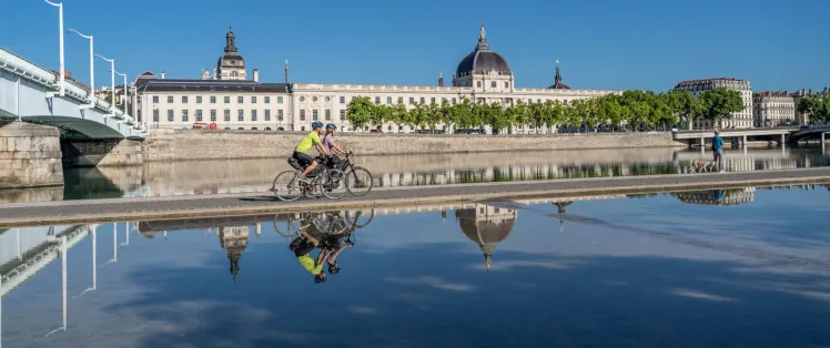 Cyclists passing in front of the Grand Hôtel-Dieu in Lyon