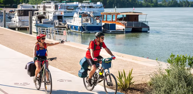 Couple cycling along the quays of Tournon sur Rhône (Ardèche)