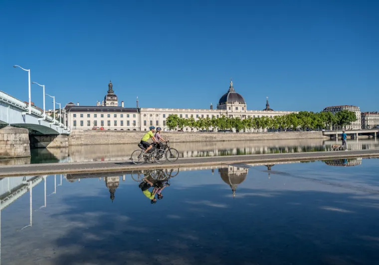 Cyclists passing in front of the Grand Hôtel-Dieu in Lyon