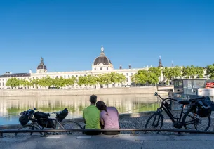 Cyclistes devant le Grand Hôtel-Dieu à Lyon